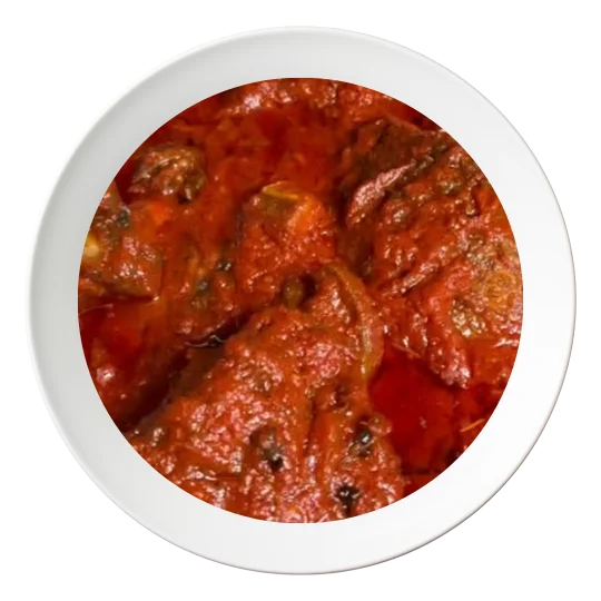 A plate of Stew with fried Tilapia fish, a Nigerian style dish, available in Bolingbrook, Illinois.